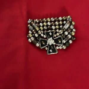 Jewelry. Large black cross with four rows of assorted beads bracelet.